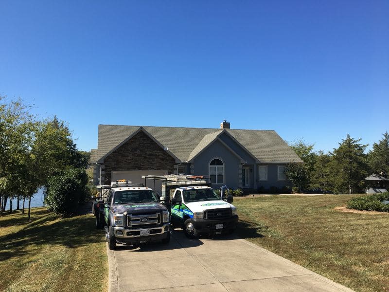 Two service company trucks of Excellent Exterior LLC in a house located in Fredericksburg.
