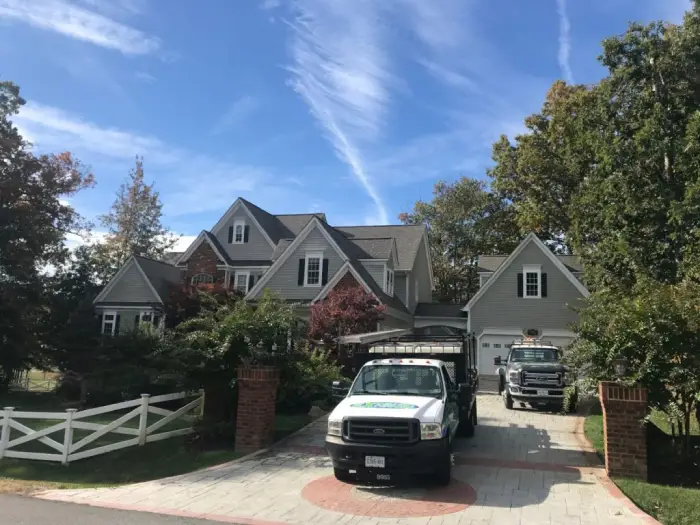 Two service company trucks of Excellent Exterior LLC in a house located in Fredericksburg.
