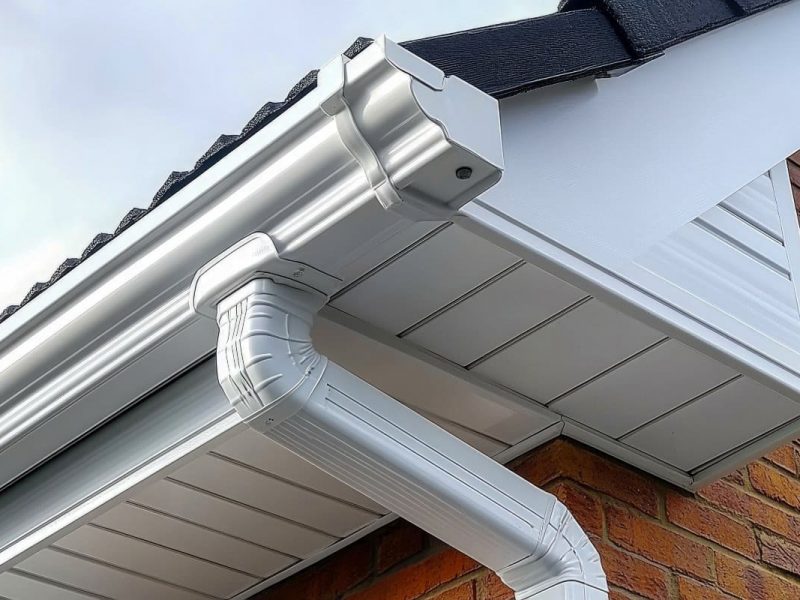 Closeup view of old white gutter system with soffit vent, window with white frame, gutter guard, downspout, decorative trim molding, on corner of brick luxury house --chaos 45 --ar 16:9 --stylize 750 --v 6.1 Job ID: b47b6ee0-33e2-48cf-b0db-442c00769eca