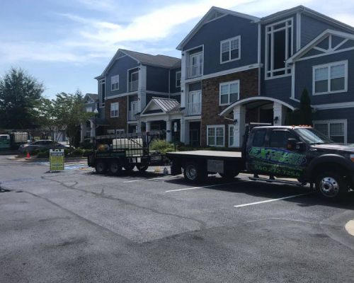 Two service company trucks of Excellent Exterior LLC are in a residential building located in Fredericksburg.
